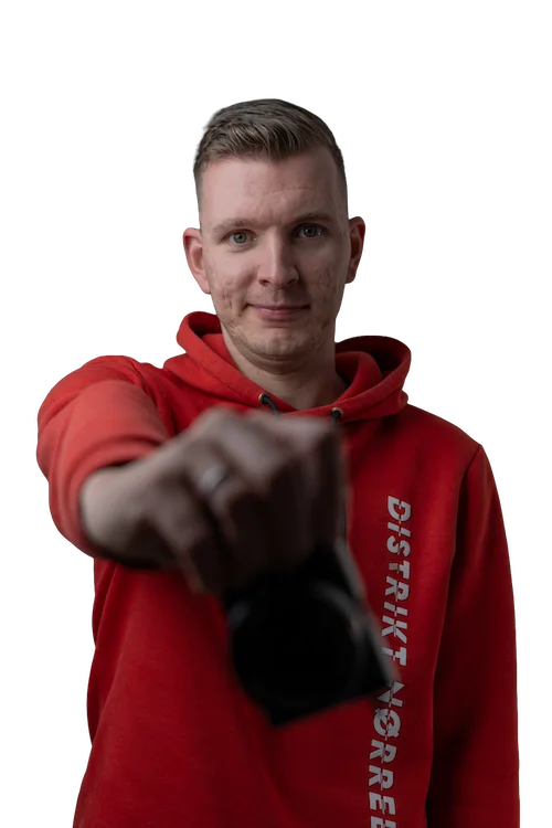 Een portret foto van Jan Doornbos die een camera voor zijn borst houdt